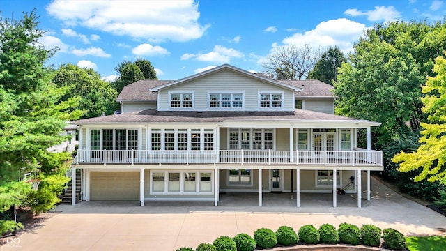 view of front facade with driveway, a shingled roof, and stairway
