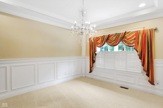 unfurnished room featuring light colored carpet, a chandelier, a wainscoted wall, visible vents, and a decorative wall
