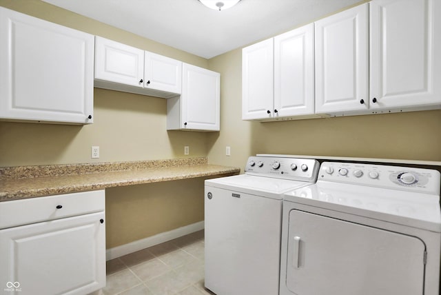 clothes washing area with washing machine and clothes dryer, cabinet space, baseboards, and light tile patterned floors