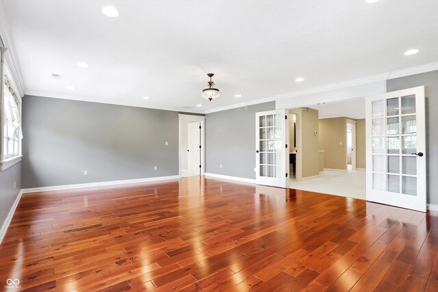 spare room with crown molding, french doors, and hardwood / wood-style flooring