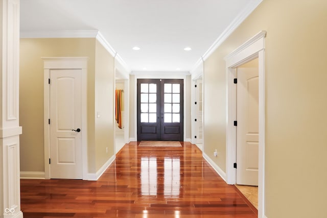 foyer featuring wood-type flooring, crown molding, and french doors