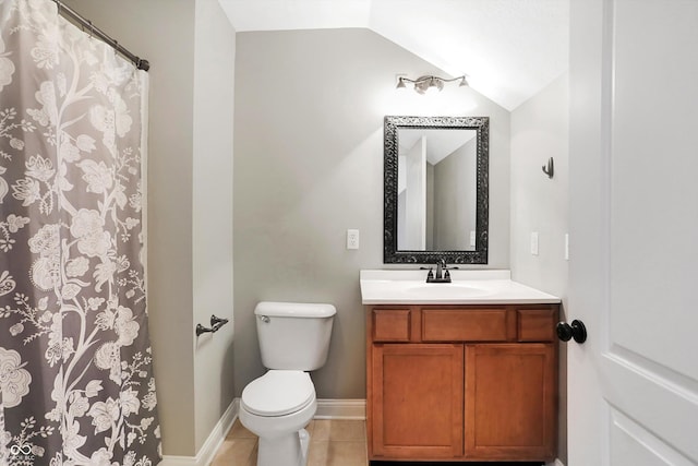 bathroom with vanity, lofted ceiling, toilet, baseboards, and tile patterned floors