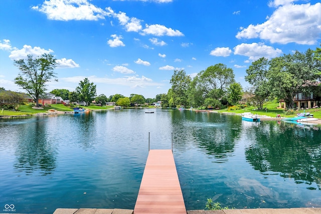 view of dock with a lawn and a water view