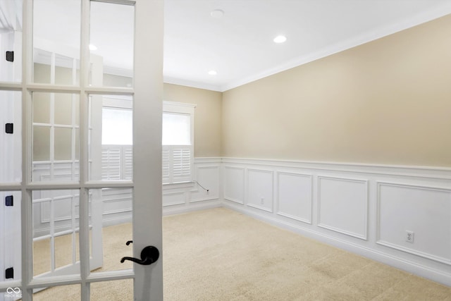 spare room with a wainscoted wall, light colored carpet, recessed lighting, and ornamental molding