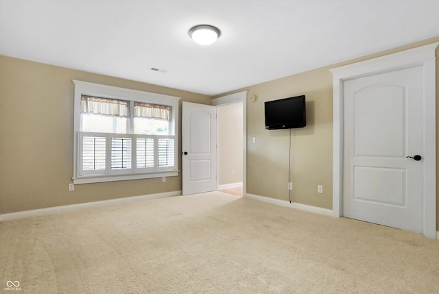 unfurnished bedroom featuring carpet floors, baseboards, and visible vents