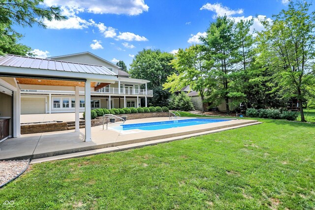 outdoor pool with a patio area and a yard