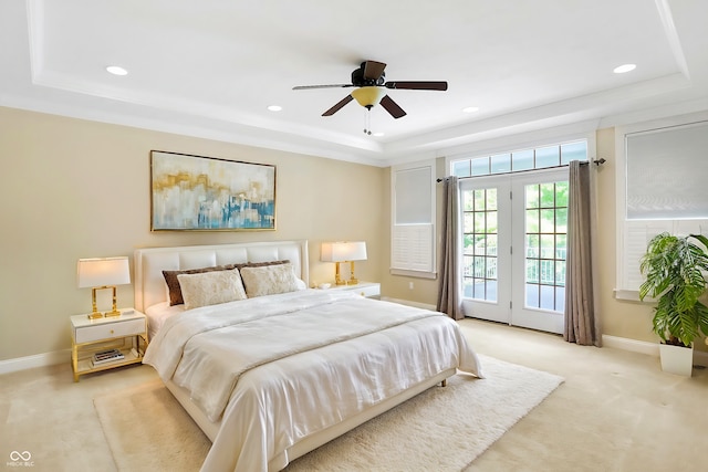 bedroom with access to outside, a tray ceiling, baseboards, and light colored carpet