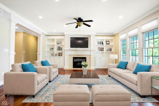 living room featuring ornate columns, ceiling fan, wood finished floors, and crown molding