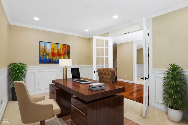 home office with crown molding and light hardwood / wood-style floors