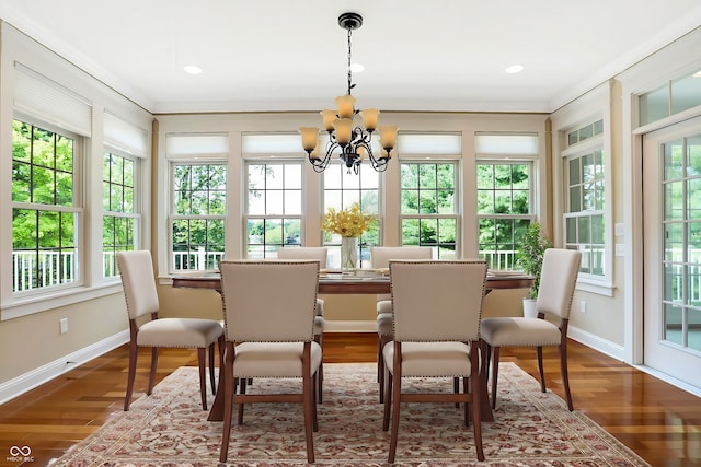 dining space with a notable chandelier, wood-type flooring, and ornamental molding