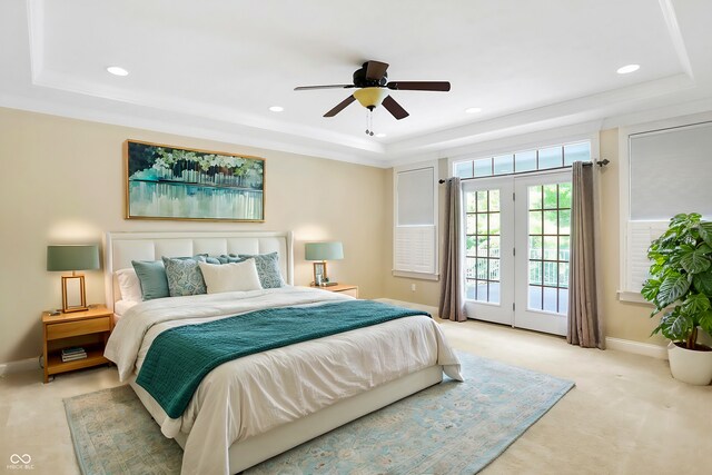 bedroom featuring a tray ceiling, ceiling fan, french doors, and access to exterior