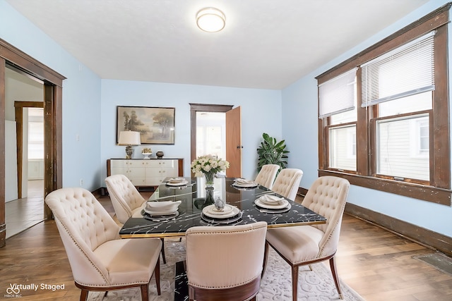 dining room with dark hardwood / wood-style flooring and plenty of natural light