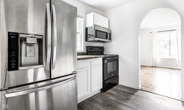 kitchen featuring white cabinets, appliances with stainless steel finishes, and dark hardwood / wood-style floors