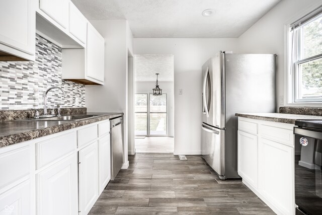 kitchen featuring sink, stainless steel appliances, white cabinets, and tasteful backsplash