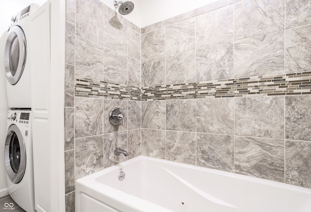 bathroom featuring tile walls, stacked washer and dryer, and tiled shower / bath combo