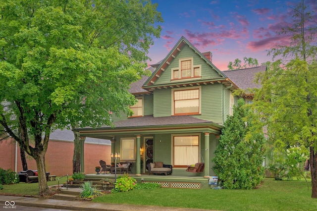 view of front of home featuring covered porch and a lawn