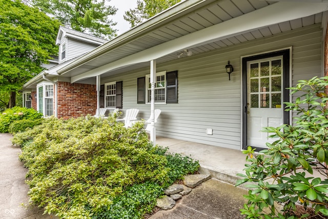 view of exterior entry featuring covered porch