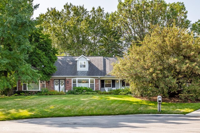 new england style home featuring a front yard