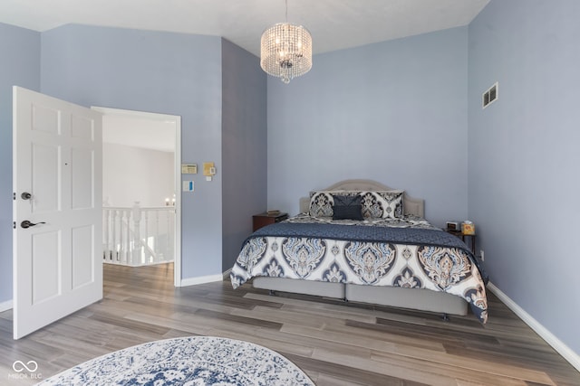 bedroom with light wood-type flooring and a chandelier