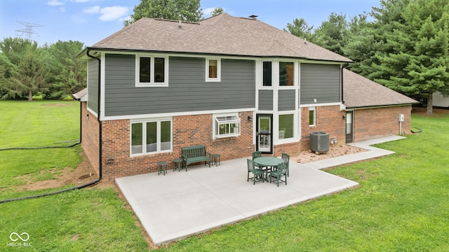 rear view of property featuring a lawn, a patio, and cooling unit