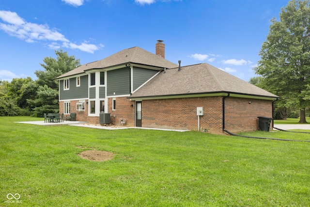 rear view of house with cooling unit, a patio, and a yard