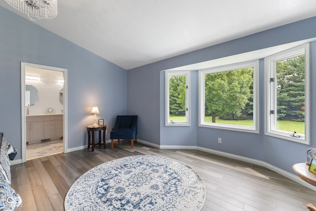 living area with lofted ceiling, hardwood / wood-style flooring, and plenty of natural light