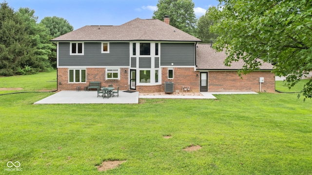 rear view of house featuring cooling unit, a patio area, and a yard