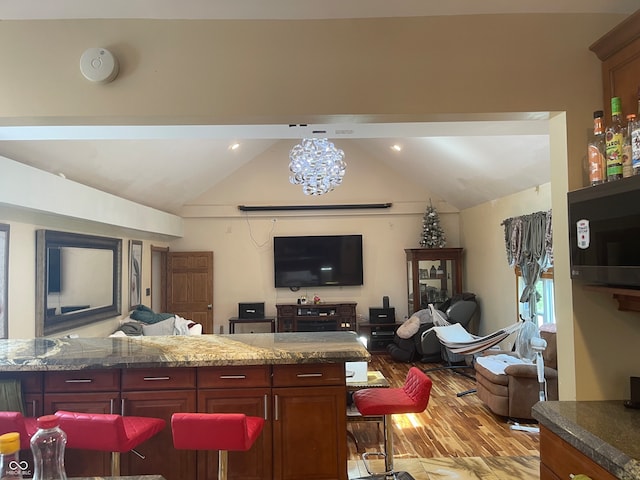 kitchen with light hardwood / wood-style floors, a notable chandelier, and lofted ceiling