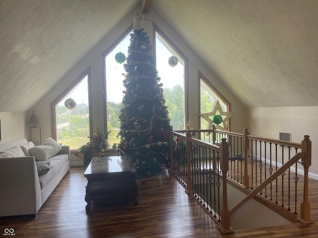 living room featuring dark hardwood / wood-style flooring, a textured ceiling, lofted ceiling, and plenty of natural light