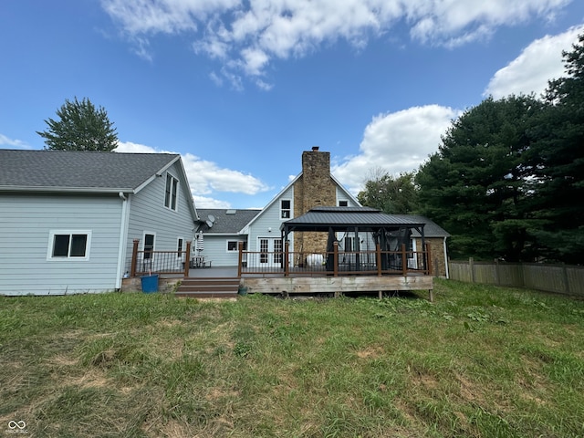 back of property featuring a gazebo, a deck, and a lawn