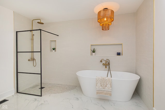 bathroom featuring plus walk in shower, tile patterned flooring, and tile walls