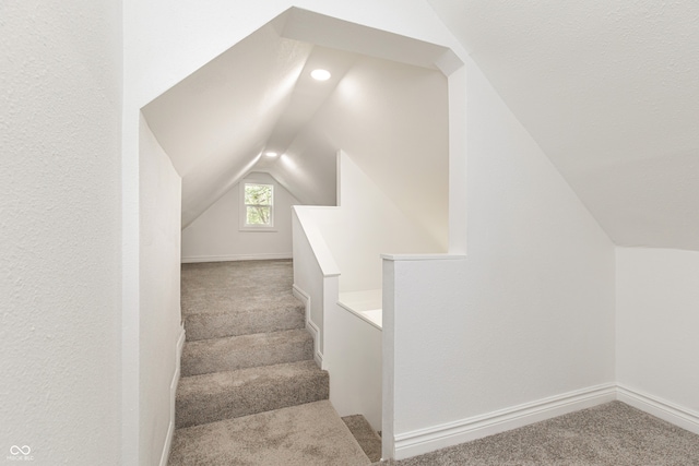 stairs with light carpet and vaulted ceiling