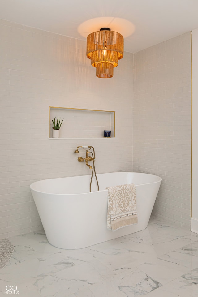 bathroom with tile patterned flooring, tile walls, and a bathtub