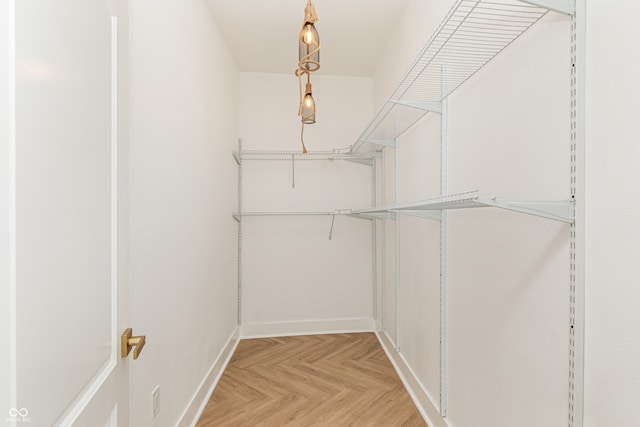 walk in closet with light parquet flooring