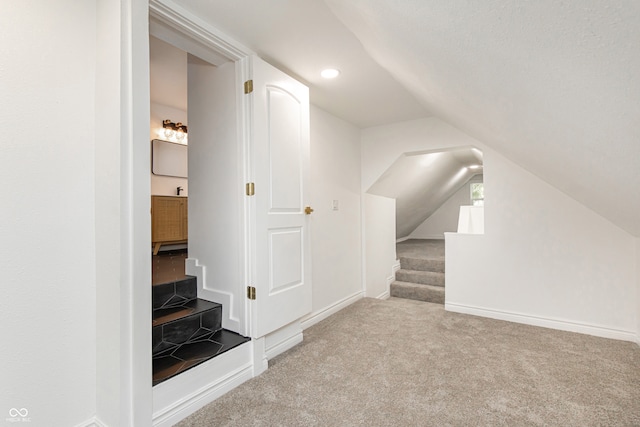 additional living space featuring carpet flooring, lofted ceiling, and a textured ceiling