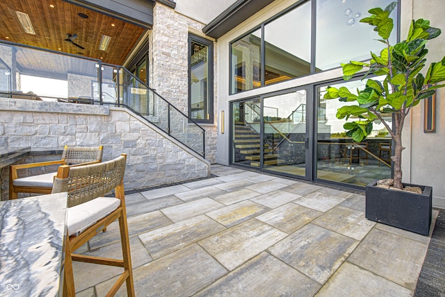 exterior space with wood ceiling and a stone fireplace