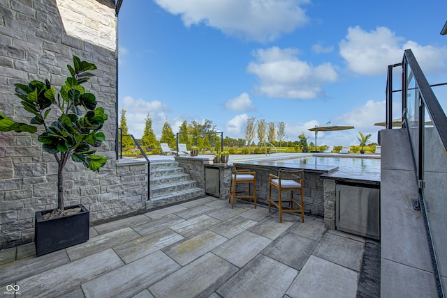 view of patio / terrace featuring an outdoor bar