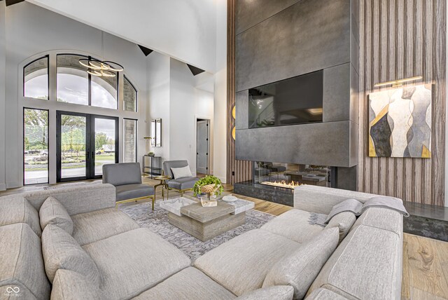 living room featuring a multi sided fireplace, hardwood / wood-style floors, and high vaulted ceiling