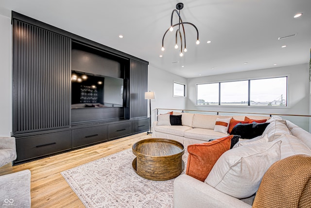 living room with light wood-type flooring and a chandelier