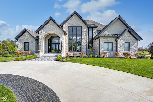 view of front of house with a front lawn, a standing seam roof, metal roof, and french doors