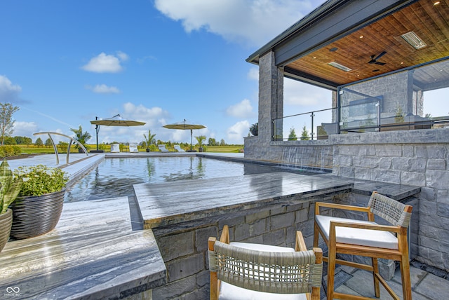 exterior space featuring ceiling fan, a bar, and a patio area