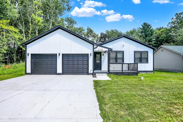 view of front of house with covered porch, a garage, and a front lawn