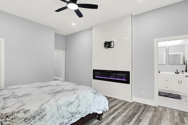 bedroom with connected bathroom, hardwood / wood-style floors, sink, and ceiling fan