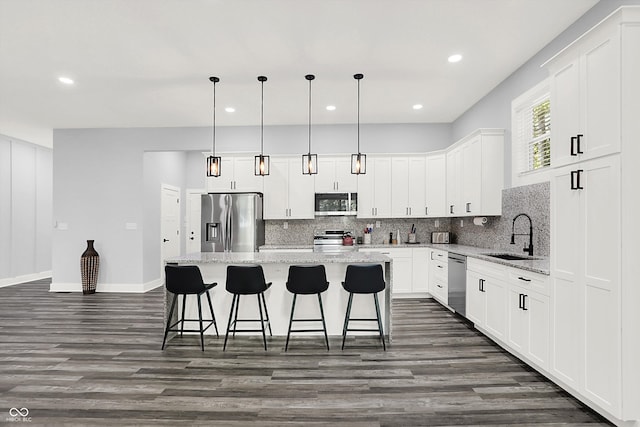 kitchen with dark hardwood / wood-style floors, backsplash, appliances with stainless steel finishes, and sink