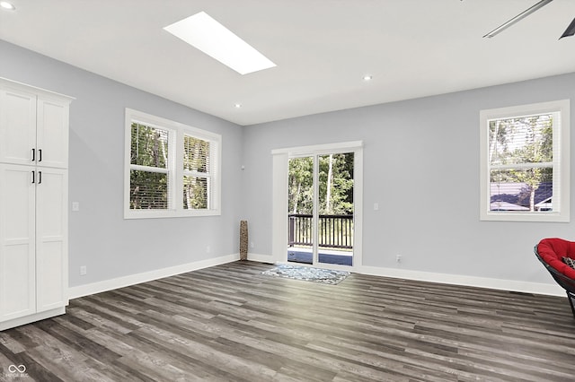 unfurnished room featuring a healthy amount of sunlight, wood-type flooring, and a skylight