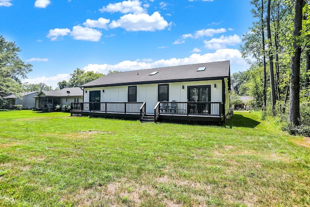 back of property featuring a yard and a wooden deck