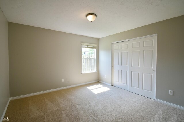 unfurnished bedroom featuring carpet and a closet