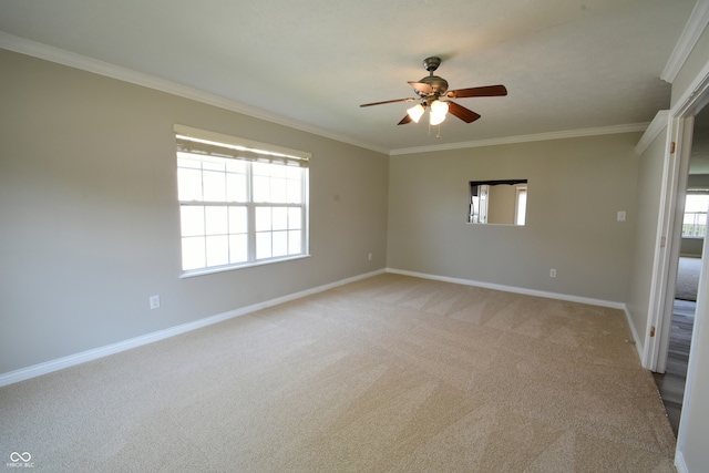 carpeted spare room featuring crown molding, ceiling fan, and a healthy amount of sunlight