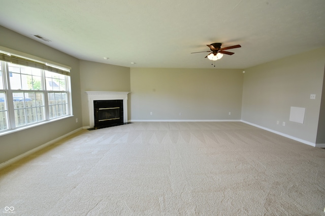 unfurnished living room with ceiling fan and light carpet