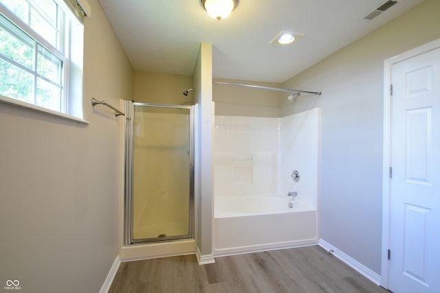 bathroom featuring shower with separate bathtub and wood-type flooring